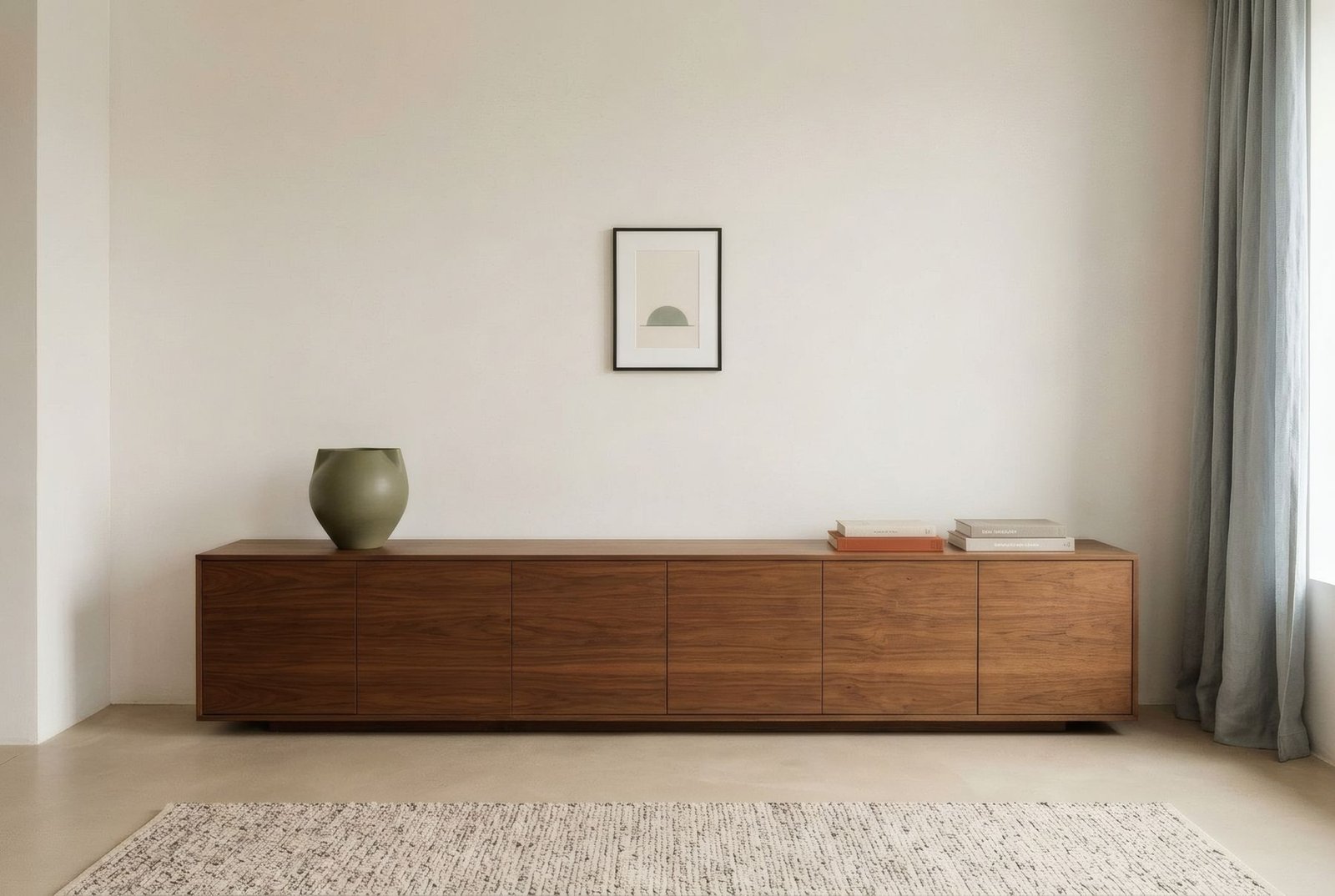 Lámina vertical pequeña sola y centrada sobre un mueble bajo muy largo, que parece perdida