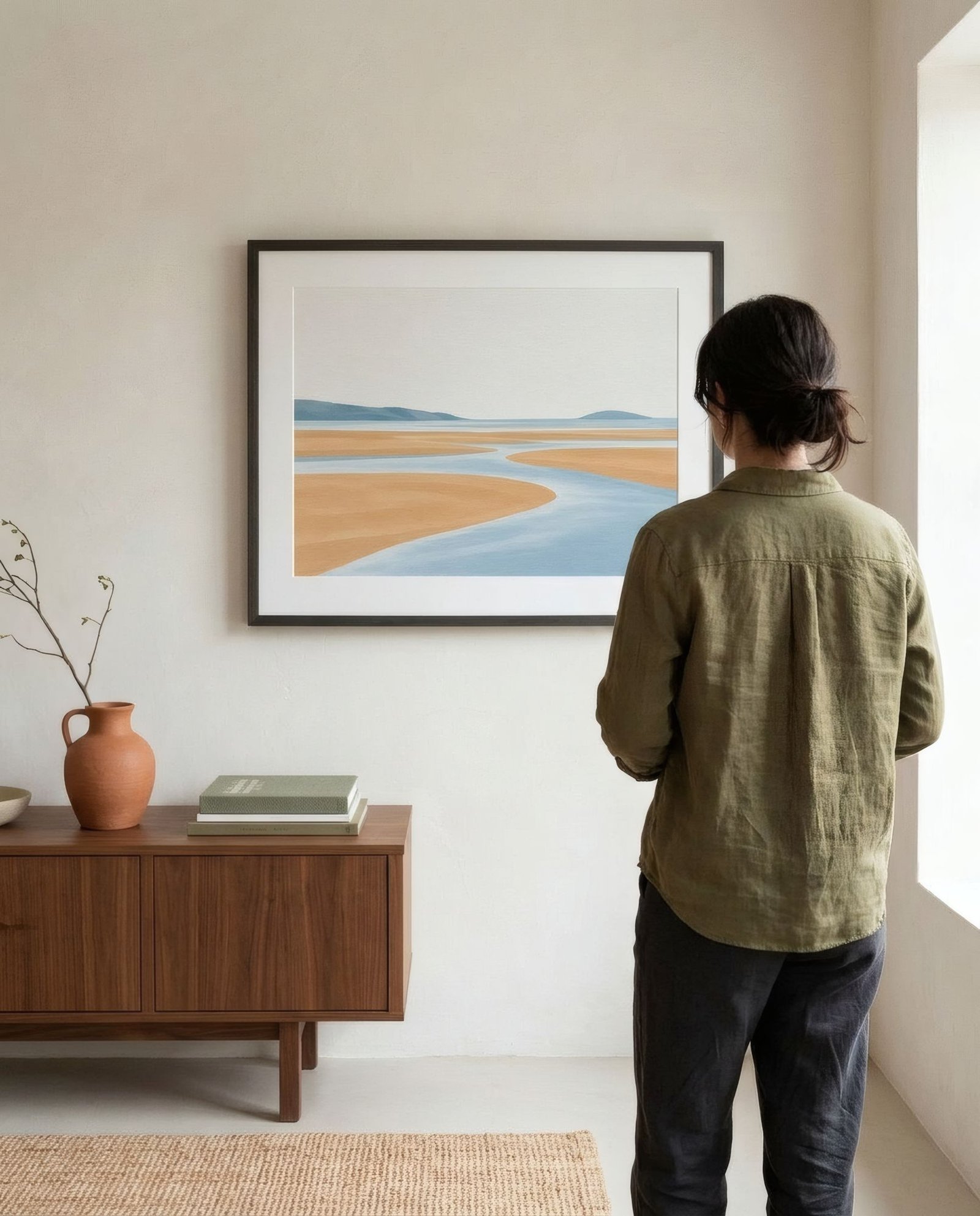 Persona vista de espaldas mirando de cerca una lámina abstracta en casa